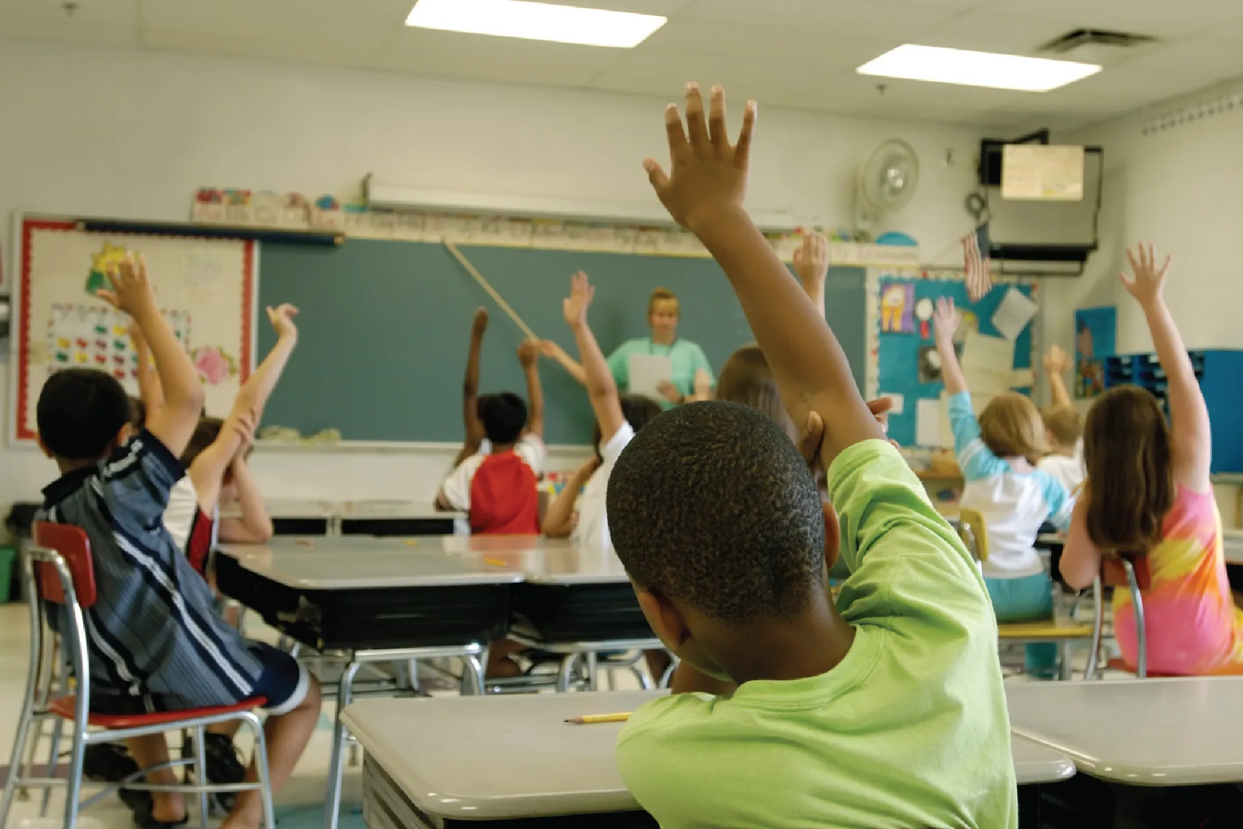 Students raising hands in classroom